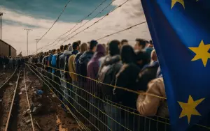 Flüchtlinge an einem Grenzzaun
