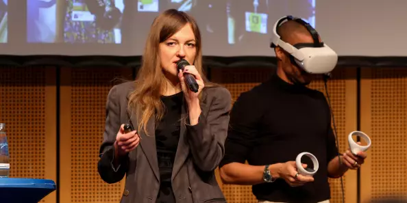 Loulia Isserlis mit Mikrofon und Dennis Lisk von Proof of Taste mit VR Brille und Controllern