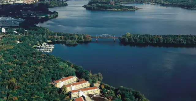 Seminaris SeeHotel Potsdam Birdview, weiter Seeblick und Hotel ragt zwischen Bäumen hervor im Vordergrund